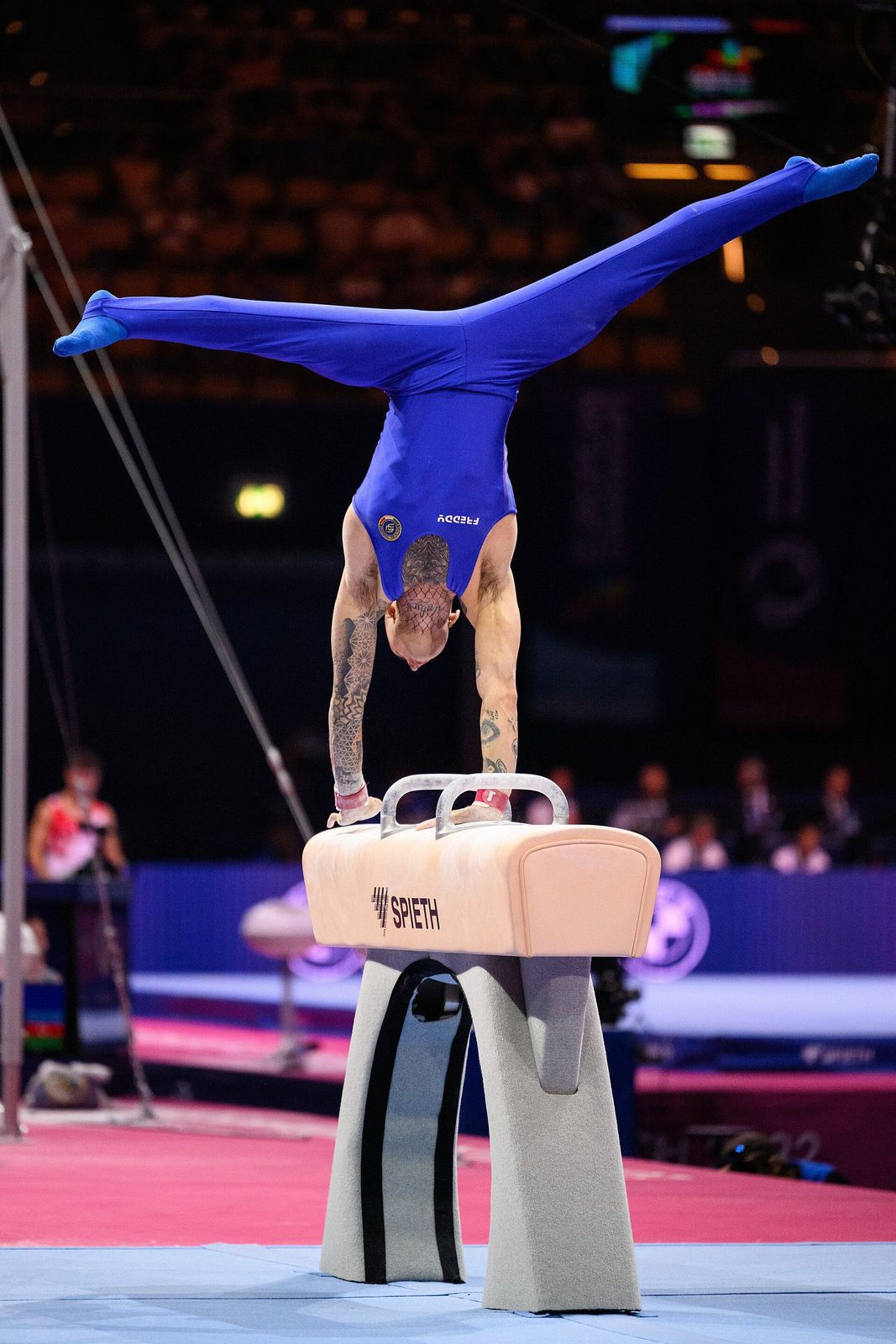 Nicola Bartolini in verticale a gambe divaricate sul cavallo con maniglie