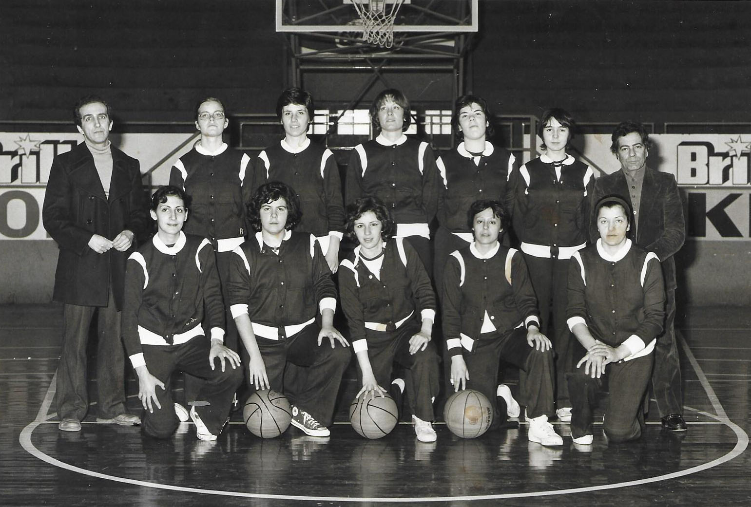 Squadra femminile di pallacanestro in posa in palestra