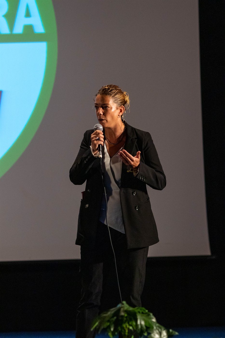 Maria Laura Orr&ugrave; sul palco al microfono, davanti a un logo proiettato