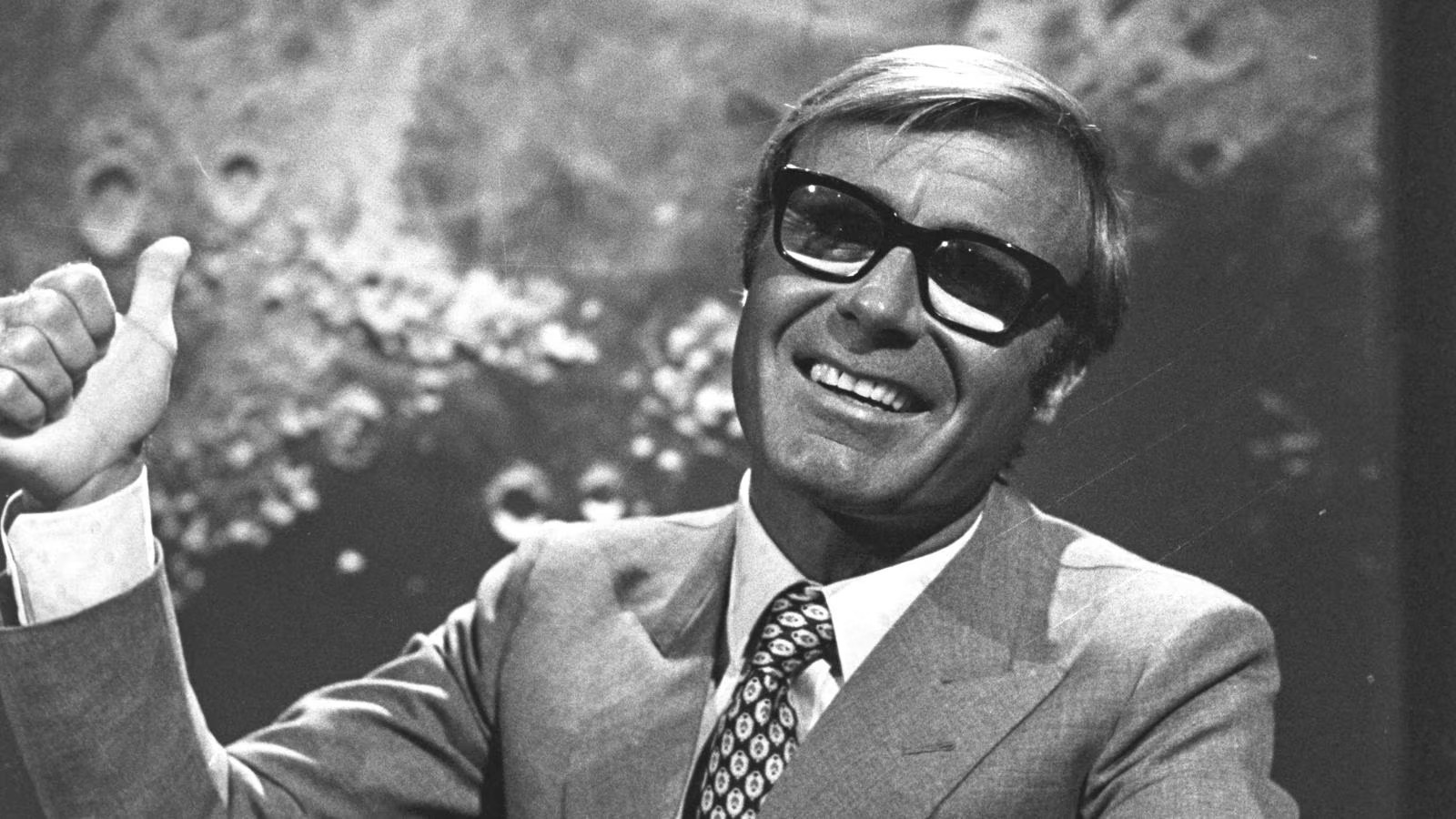 Tito Stagno in studio, davanti allo sfondo lunare